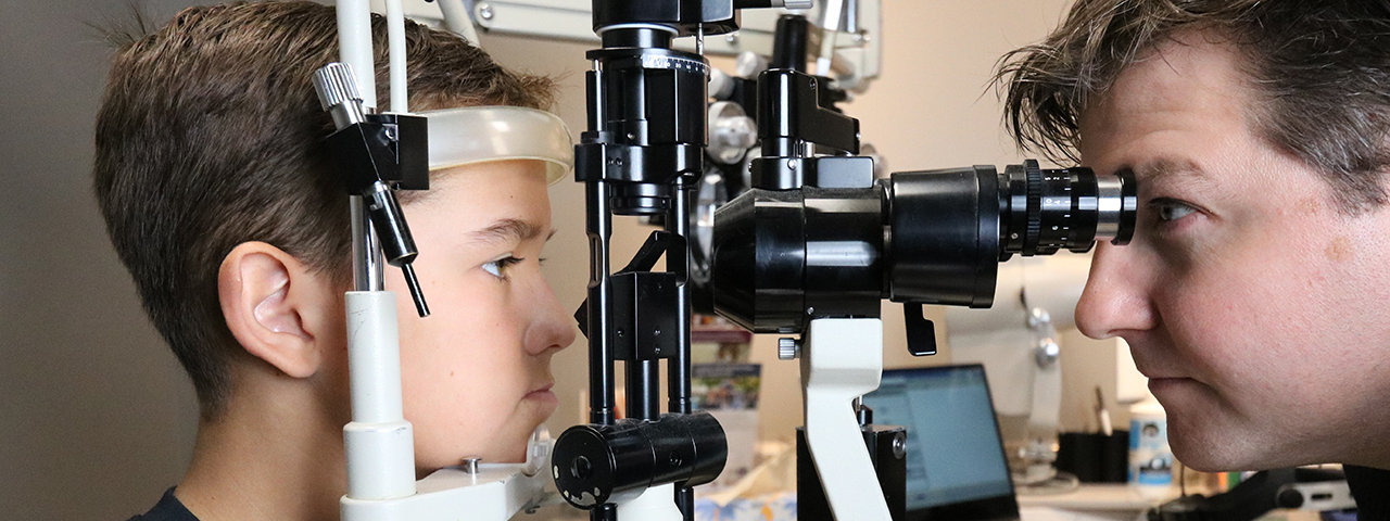 Photo of Dr. Baker giving a comprehensive eye exam to a patient.